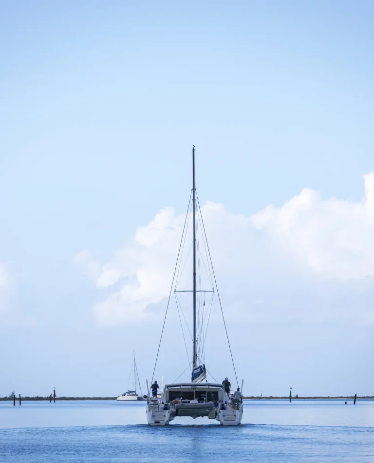 Catamaran Purboat Karribean quittant un mouillage paisible au petit matin.